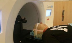 A child watches a movie while undergoing radiotherapy treatment. Credit: VLADI project
