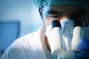 Male researcher microscope mask