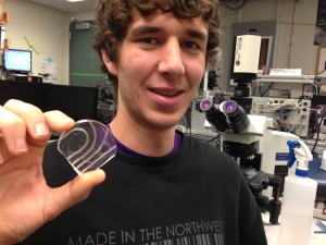 Undergraduate mechanical engineering student Chris Burfeind holds the prototype in the UW mechanical engineering lab. Burfeind built this device using flexible Teflon tubes and a petri dish. Photo: University of Washington 