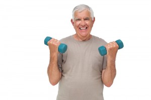Portrait of a happy senior man exercising with dumbbells