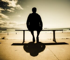Young Man In Silhouette Sitting In The Sun