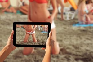 Woman taking pictures on a tablet Girls on a beach