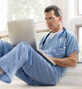 senior male doctor with computer